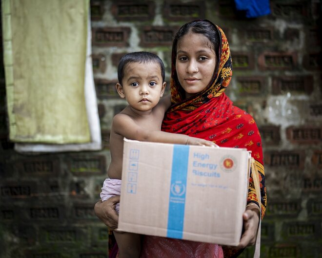 Zakia and her two-year-old, Shimu, at the ward commissioner’s office in Masimpur to collect micronutrient fortified biscuits. © WFP/Sayed Asif Mahmud