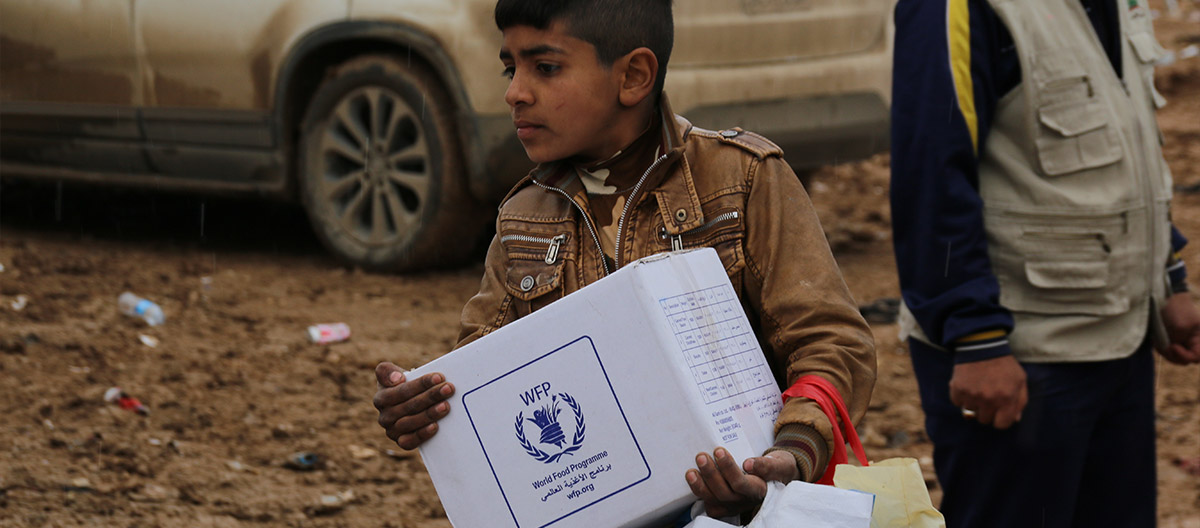 Boy carrying box of food assistance