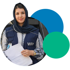 Young woman wearing a WFP-branded vest and badge holding some work documents 