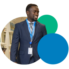 Man wearing a navy blue blazer and a WFP badge is walking inside WFP's office