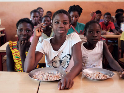 Students receive hot meals provided by School Feeding Programme after the class.