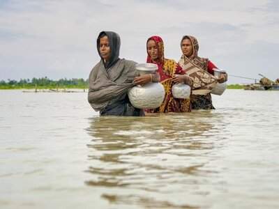 Photo: WFP/Sayed Asif Mahmud Three women walking in a flooded place