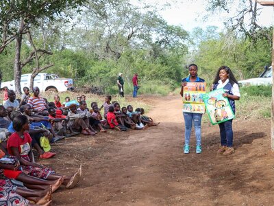 Two WFP staff educating people about their rights when receiving humanitarian assistance to prevent abuses of power and violence. 