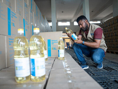 WFP/Saikat Mojumder WFP employee inspecting boxes of sunflower oil procured for WFP food assistance baskets.