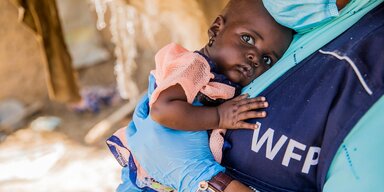 WFP staff member with Hassana,  a 10-month-old recovering from malnutrition after WFP intervention.