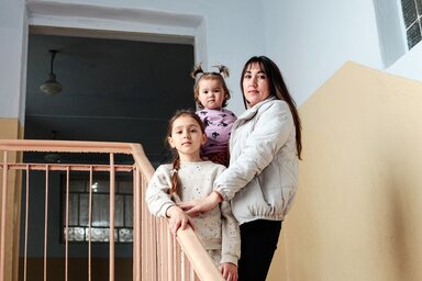 © WFP/Arete/Serge Poliakov Mother Bobyleva Regina Petrivna, 32 years old, poses for a photograph with her children, Bobyleva Sofia Sergiivna, 1 year old, and Bobyleva Sabina Sergiivna, 8 years old, on a stairwell in the Sarata's Lyceum.