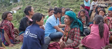 WFP staff talking to a group of beneficiaries