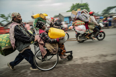 A man runs as he pushes a wheelchair user's wheelchair