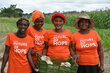 Group of 4 women trained to farm mushrooms standing outside the hub