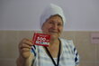 Kitchen Manager Tatiana holds a WFP commodity voucher used to purchase food for the Refugee Accommodation Centre (RAC) at local grocery stores. Photo: WFP/Kyle Wilkinson