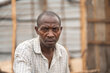 A displaced man in a shirt looking pensive