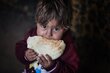 © WFP/Ali Jadallah Abboud eating a loaf of freshly baked bread that this mom baked in their clay oven with the wheat flour they receive from WFP
