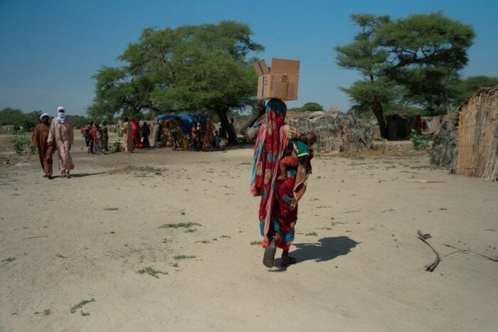 a woman is carrying a box over her head