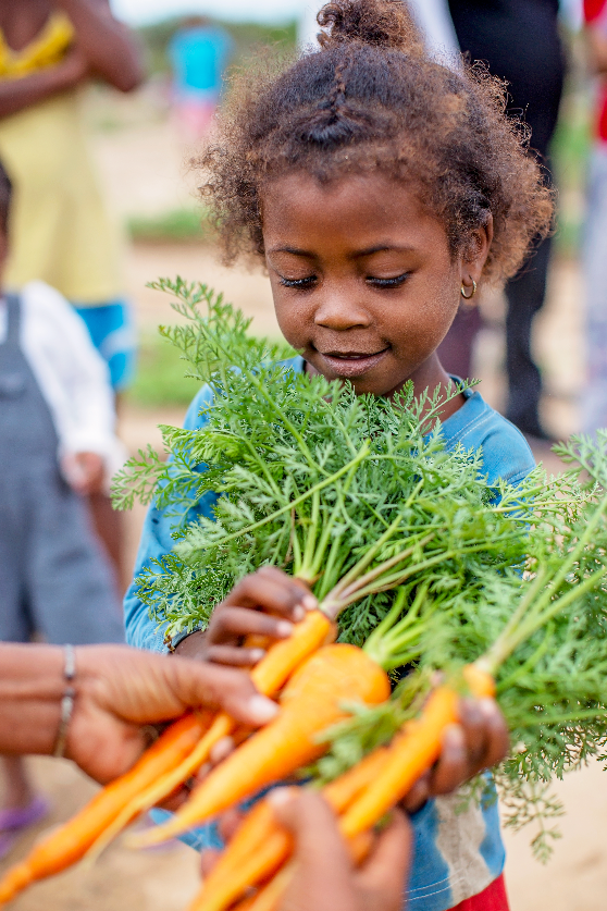 a child is holding carrots