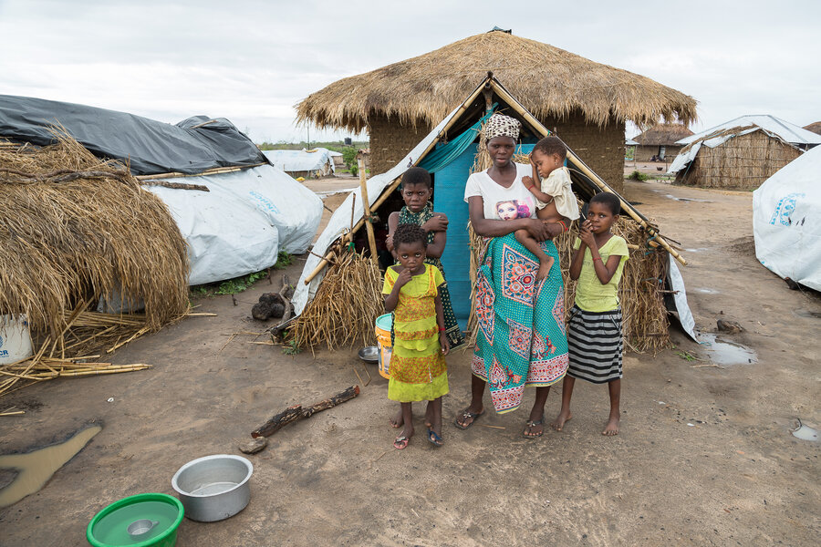 Ancha and her daughters in front of their temporary shelter in 25 de Junho 