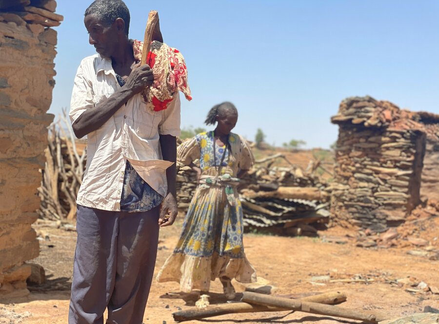 Aster and her husband Tesfay stand in the remains of their home which was set ablaze. Photo: WFP/Claire Nevill