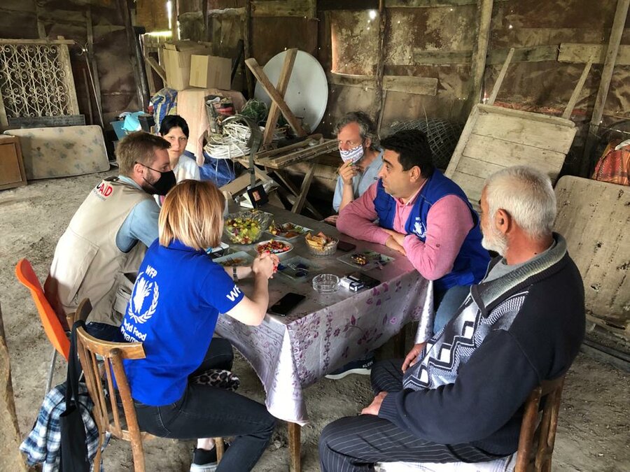 Arpine and her father in conversation with WFP staff at their simple dinner table 