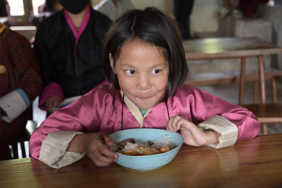 Child sitting and eating from bowl