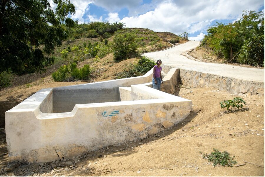 Sainteleine Ertilus standing next to a watering trough that was recently built by community members as part of the project. Photo: WFP/Theresa Piorr