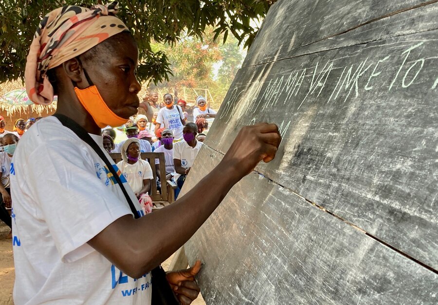 A women writes with chalk on a blackboard