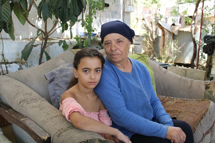 Awatef with one of her grandchildren whom she regards as the source of her happiness. Photo: WFP/Dana Houalla