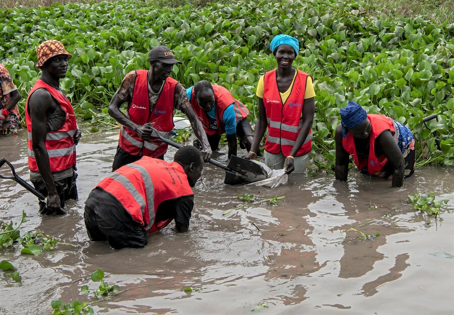 Elizabeth (with blue scarf) plans to use wages from the WFP dyke project to pay for food, her children's school fees and livestock. Photo: WFP/Alessandro Abbonizio