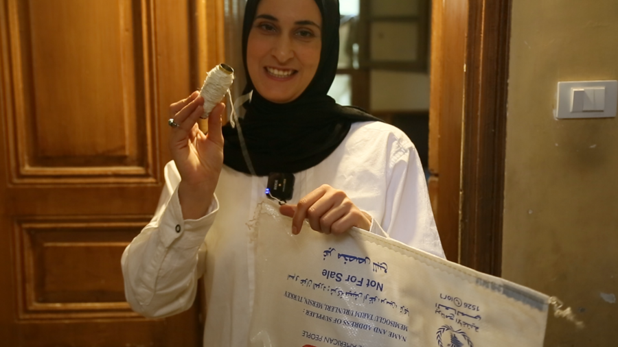 Kawthar uses the thread from the bag to sew parts of her furniture.