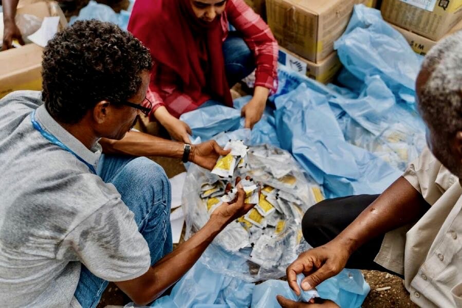 WFP staff distribute nutritional supplements to the newly arrived orphans from Khartoum. Photo: OCHA/Ala Kheir