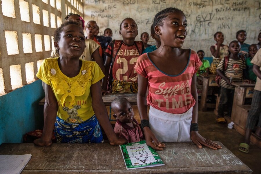 Annie (R) studies at ORA Bondzokou school, where she receives WFP-supported school meals. Photo: WFP/Gabriela Vivacqua