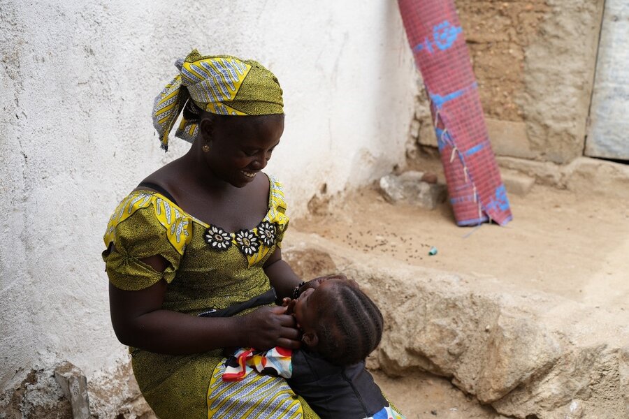 Chrisitina - an internally displaced person, with one of her children in the courtyard of the house where she and her family have found refuge.