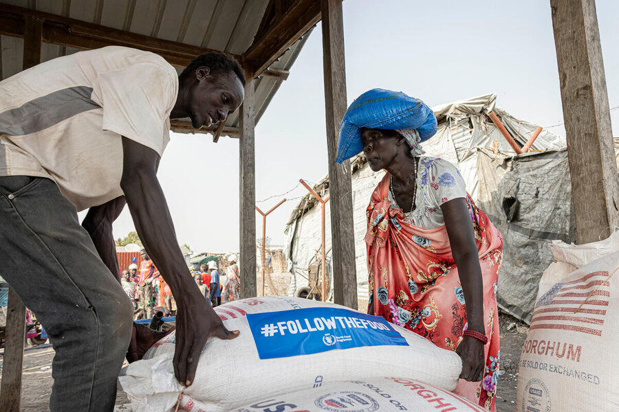 A woman collects a bag of food assistance in South Sudab