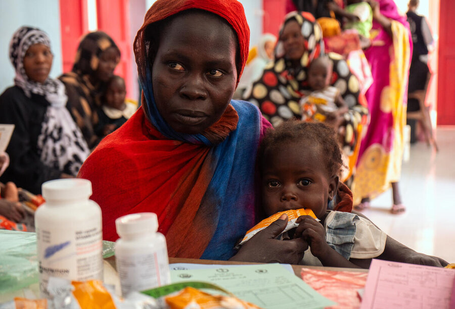 In the photo: Sittna eats her daily ration of MAM-treating supplements while her mother Magedah gets instruction from the nutrition officer at Philippe nutrition centre in Portsudan.