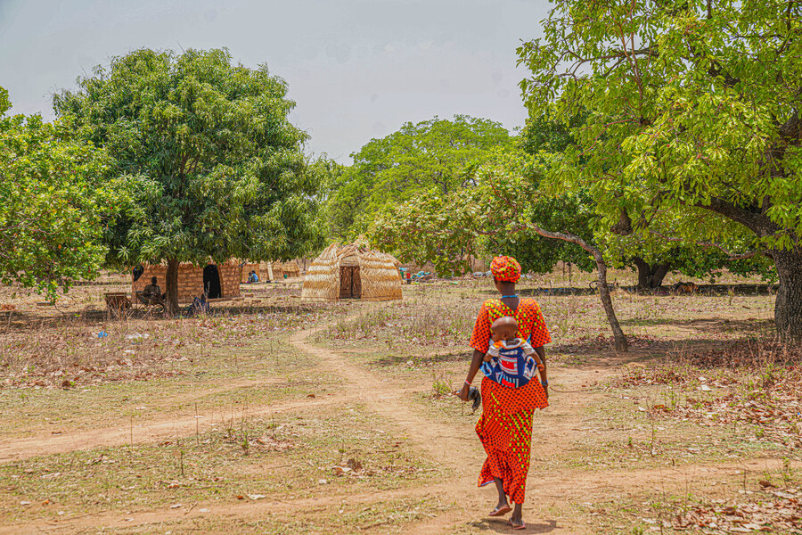 Rainatou and her youngest child head home in the Ivorian town of Serifresso, where her family depends on support from local residents and WFP. Photo: WFP/Richard Mbouet