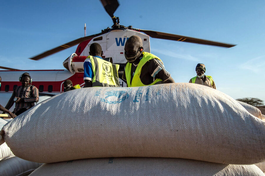 Man unloading sacks from a WFP helicopter