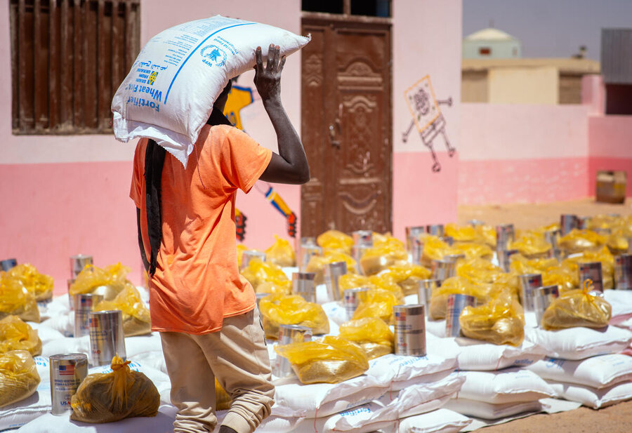 A man carries home WFP wheat flour in Northern State. Hunger has skyrocketed during Sudan's civil war. Photo: WFP/Abubakar Garelnabei