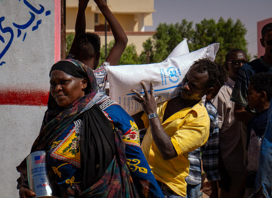 A women collects WFP food assistance in northern Sudan, even as humanitarian deliveries to the capital remain challenging. Photo: WFP/Abubakar Garelnabei