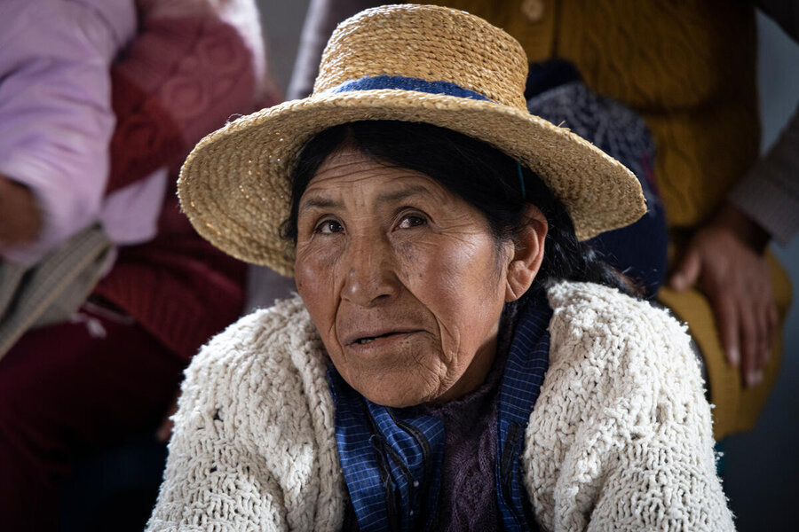 Bolivian indigenous woman in a straw hat looking into camera