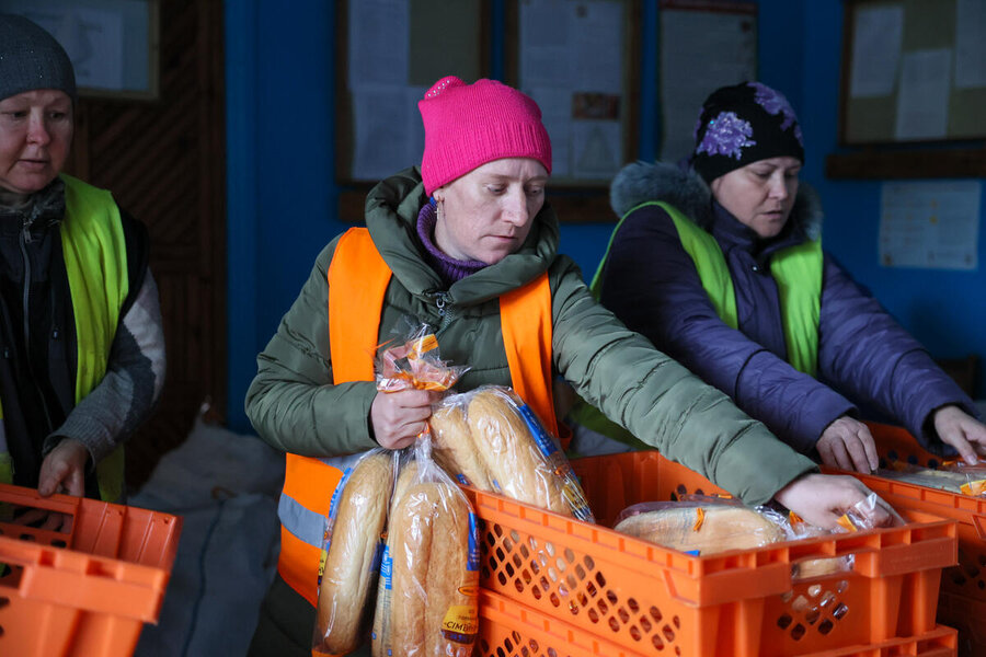 A woman sorting through crates of bread