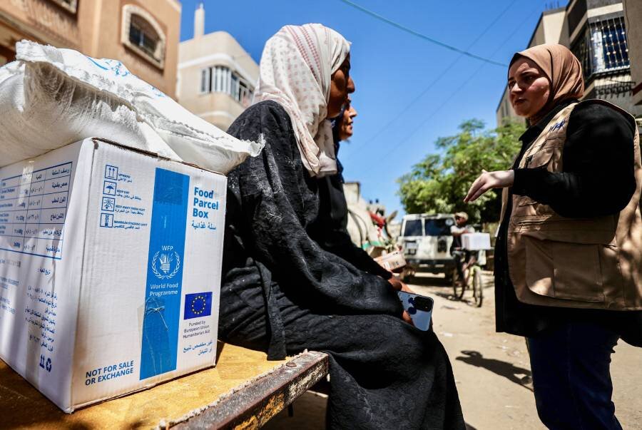 WFP's Nour Hammad (R) speaks to women collecting our assistance. Photo: WFP