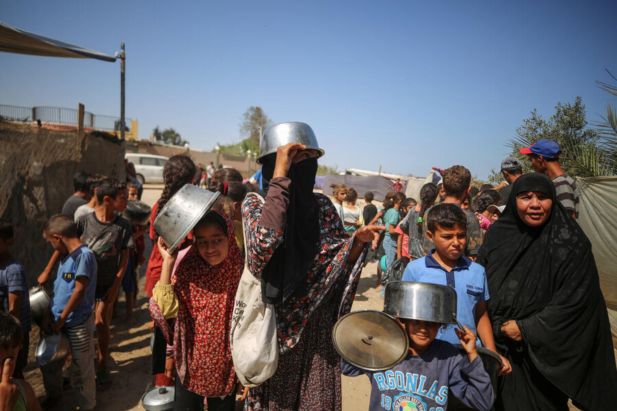 People await hot food from a WFP-supported community kitchen in the southern Gazan city of Rafah. Photo: WFP/Ali Jadallah 