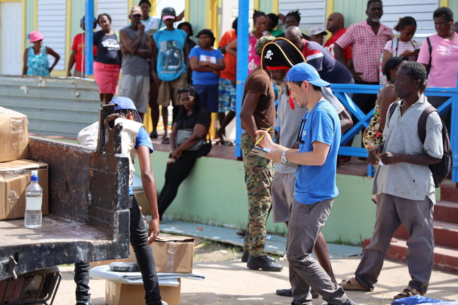 Coris Dember (with pirate hat) collects his WFP food kit on Union Island. Photo: WFP/Bryanna Hadaway