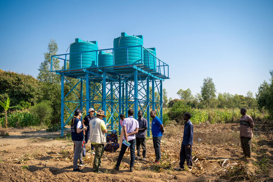 WFP personnel inspect the water tanks irrigating the fields of Nyamalo village in Phalombe, Malawi. Photo: WFP/Giulio d'Adamo