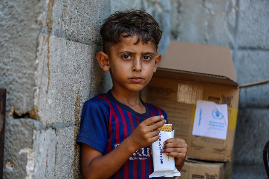 A boy in Gaza eats a WFP high-energy biscuit. Our food distributions to the strip have plummeted for lack of access. Photo: WFP/Ali Jadallah