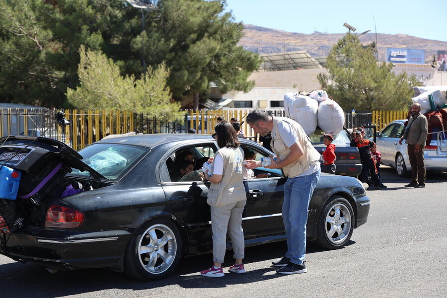 WFP staff hand out nutritious date bars to people escaping Lebanon's conflict, at a Syrian border crossing near Damascus. Photo: WFP/Hussam Al Saleh