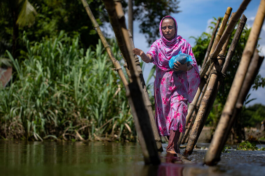 A women navigates floods in Bangladesh. In most cases our support targets women, who are likely to use it to benefit their entire families. Photo: WFP/Mumit M