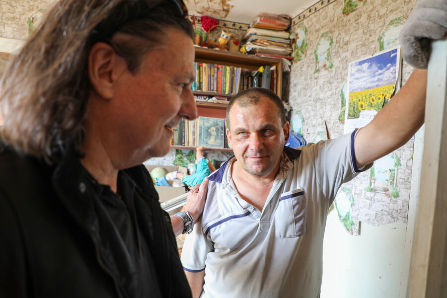 WFP Ukraine Country Director Richard Ragan (L) visits with Andriy (R), as he cleans up his missile-hit home. WFP/Niema Abdelmageed