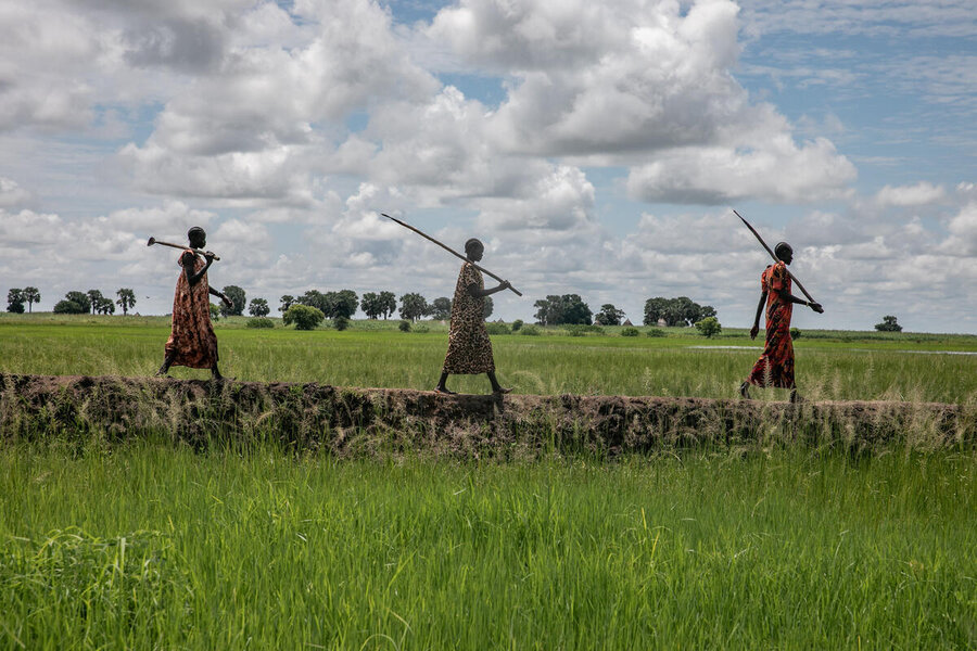 Three woman walking across a flood-control dyke.