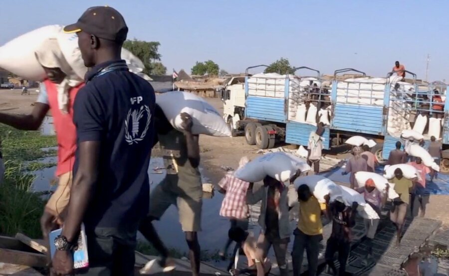 Workers load up WFP food aboard a barge in Renk, South Sudan, bound for Sudan. Photo: WFP/Peter Louis