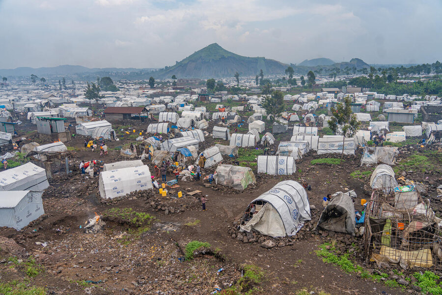 A sprawl of tents in a camp with the backdrop of a mountain