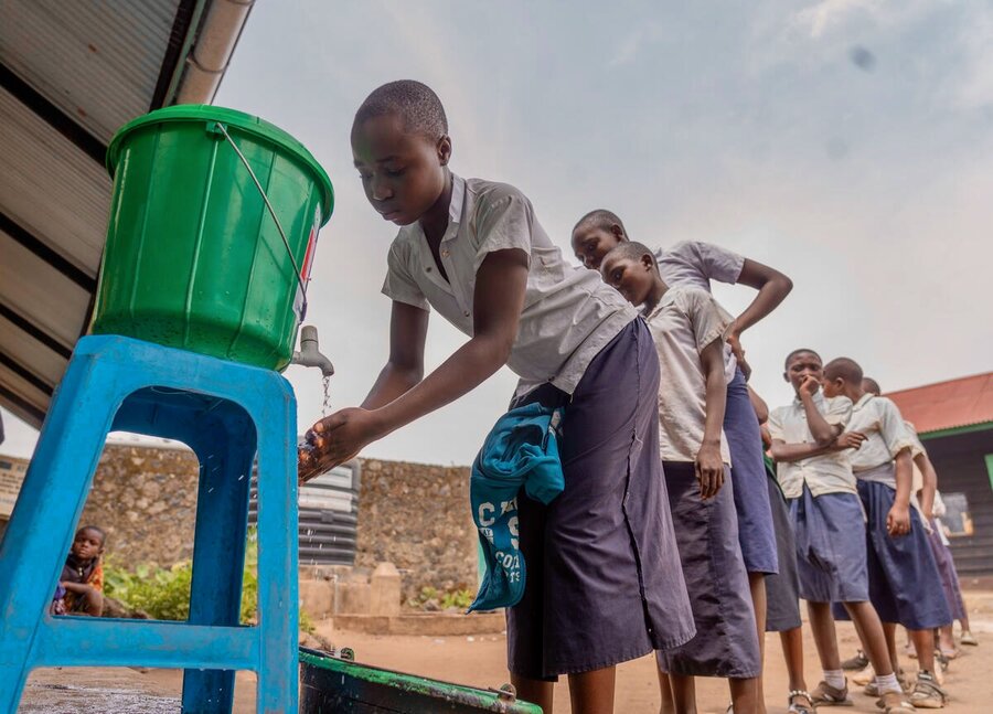 Young students wash their hands before a WFP meal in northeastern DRC. In Africa and elsewhere, school feeding offers high-impact returns. WFP/Benjamin Anguandia